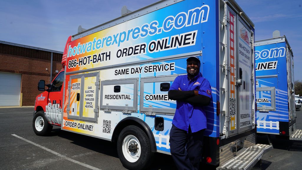 Mr. Earl beside the branded Hot Water Express same-day service trucks