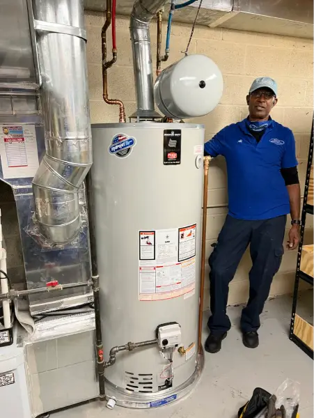 Plumber standing beside a new hot water installation