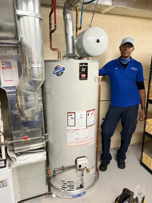 Plumber standing beside a new hot water installation